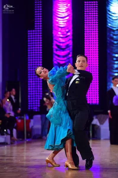 Dancesport competitor: Female dancer: teal ballroom gown with a shimmering, textured bodice and a long,