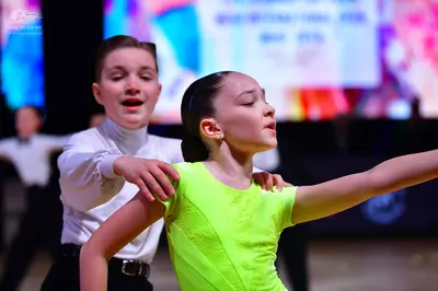 Dancesport competitor: Male dancer: white long-sleeved shirt and black trousers with a black belt