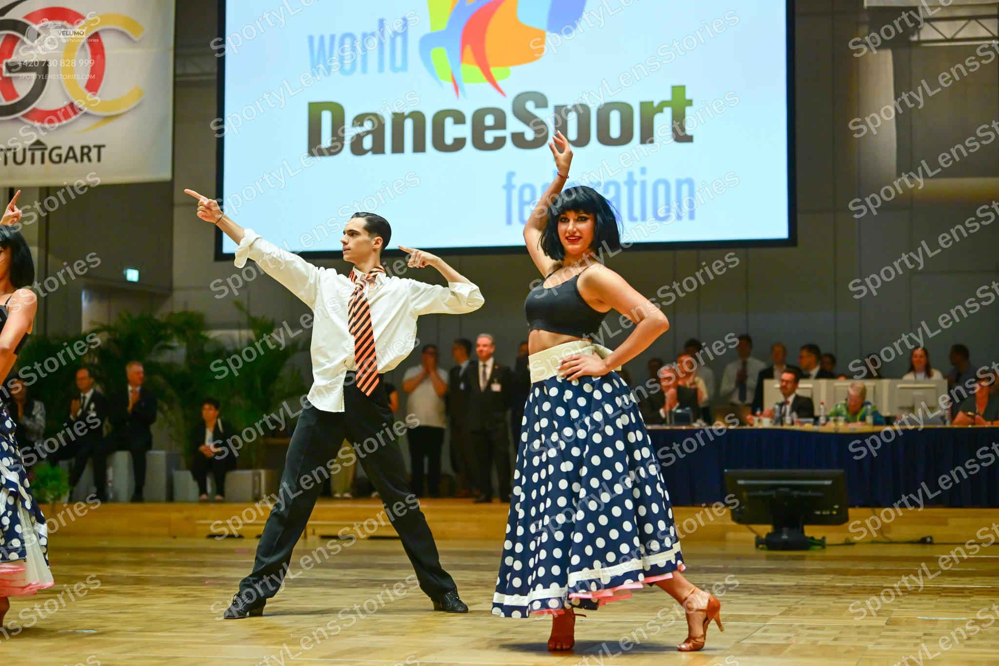 Dancesport competitor: Male dancer: white long-sleeved button-down shirt, patterned tie, and black trou