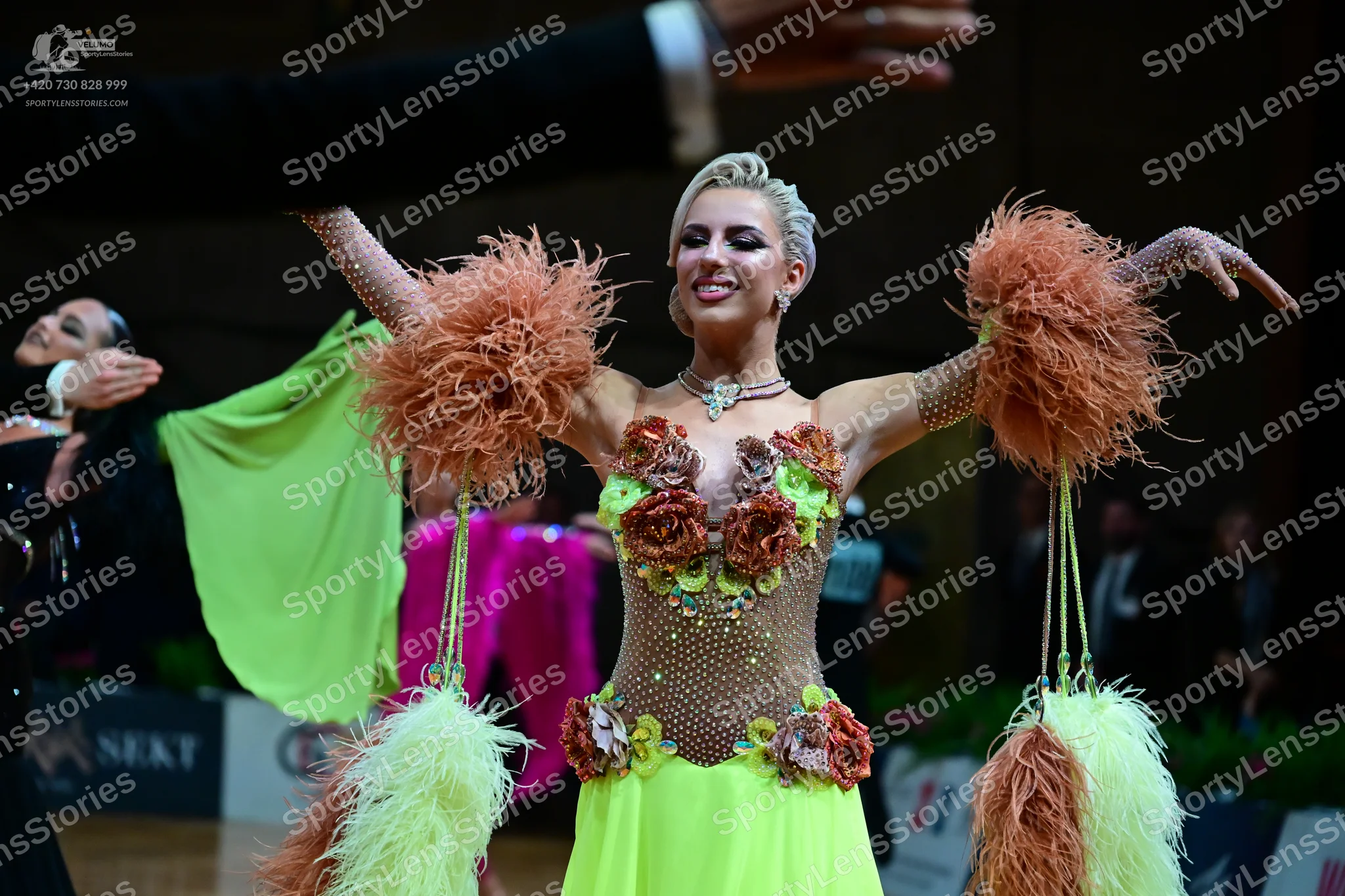 Dancesport competitor: Female dancer: lime green and nude-colored latin dance dress with rhinestone emb