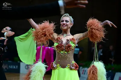 Dancesport competitor: Female dancer: lime green and nude-colored latin dance dress with rhinestone emb