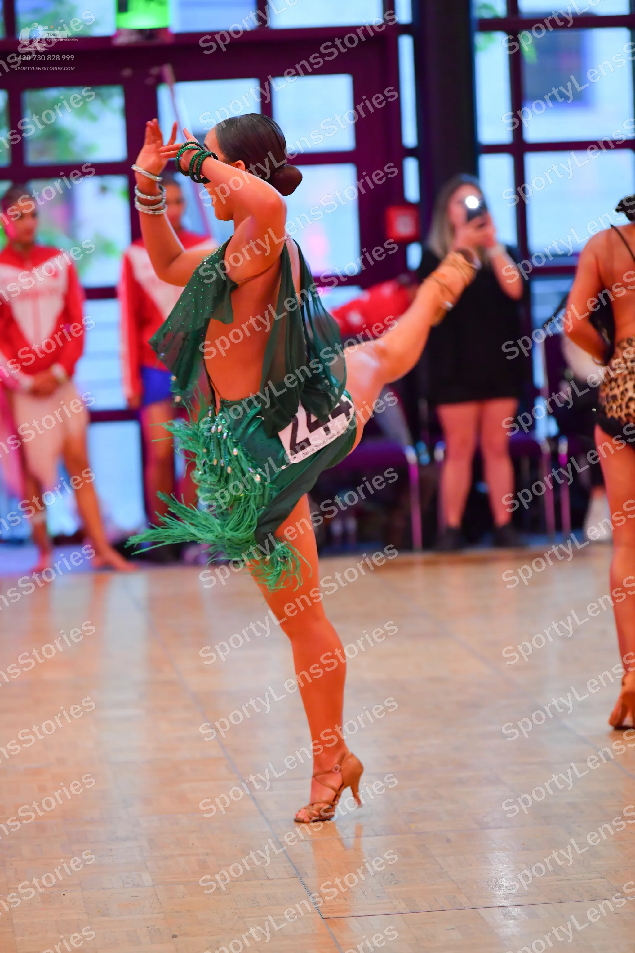 Dancesport competitor #244: Female dancer in foreground: green Latin dress with fringe and sequins, backless