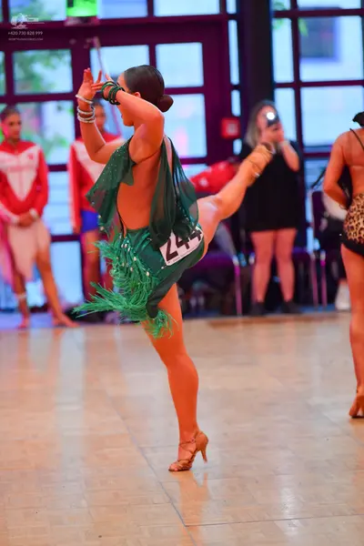 Dancesport competitor #244: Female dancer in foreground: green Latin dress with fringe and sequins, backless
