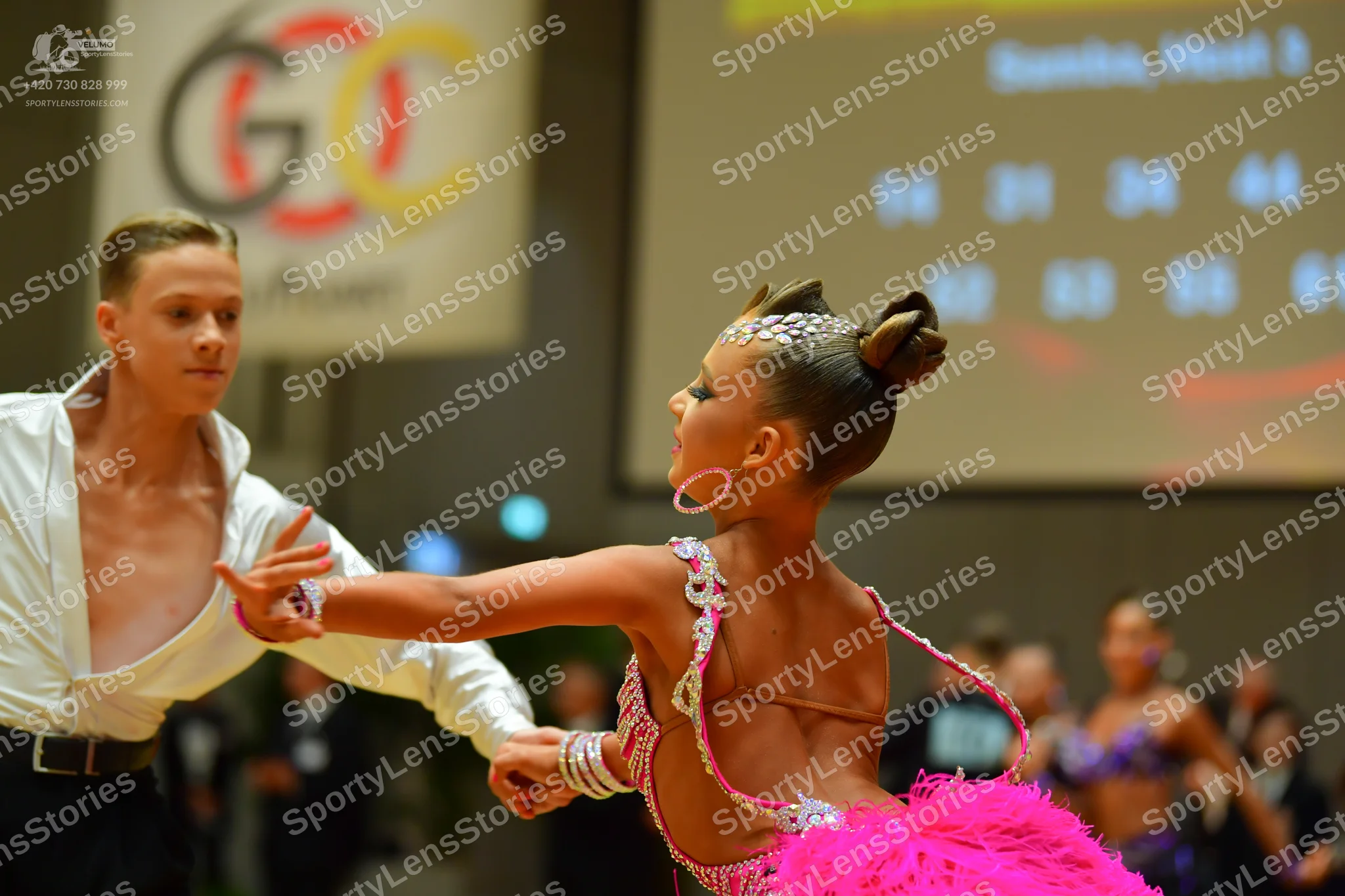 Dancesport competitor: Male dancer: white long-sleeved shirt with a deep V-neckline and black trousers
