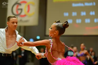 Dancesport competitor: Male dancer: white long-sleeved shirt with a deep V-neckline and black trousers 