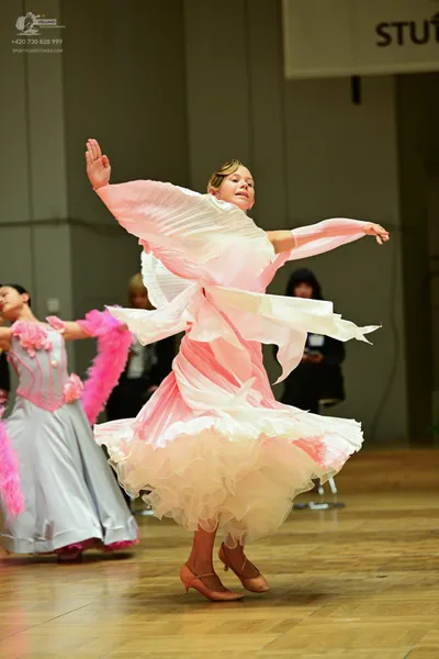Dancesport competitor: Female**

*   **Color:** Light Pink
*   **Fabric:** Pleated chiffon (appears to 