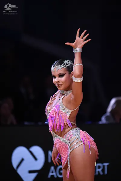 Dancesport competitor: Female dancer: pink latin dance costume with silver crystals and long pink fring