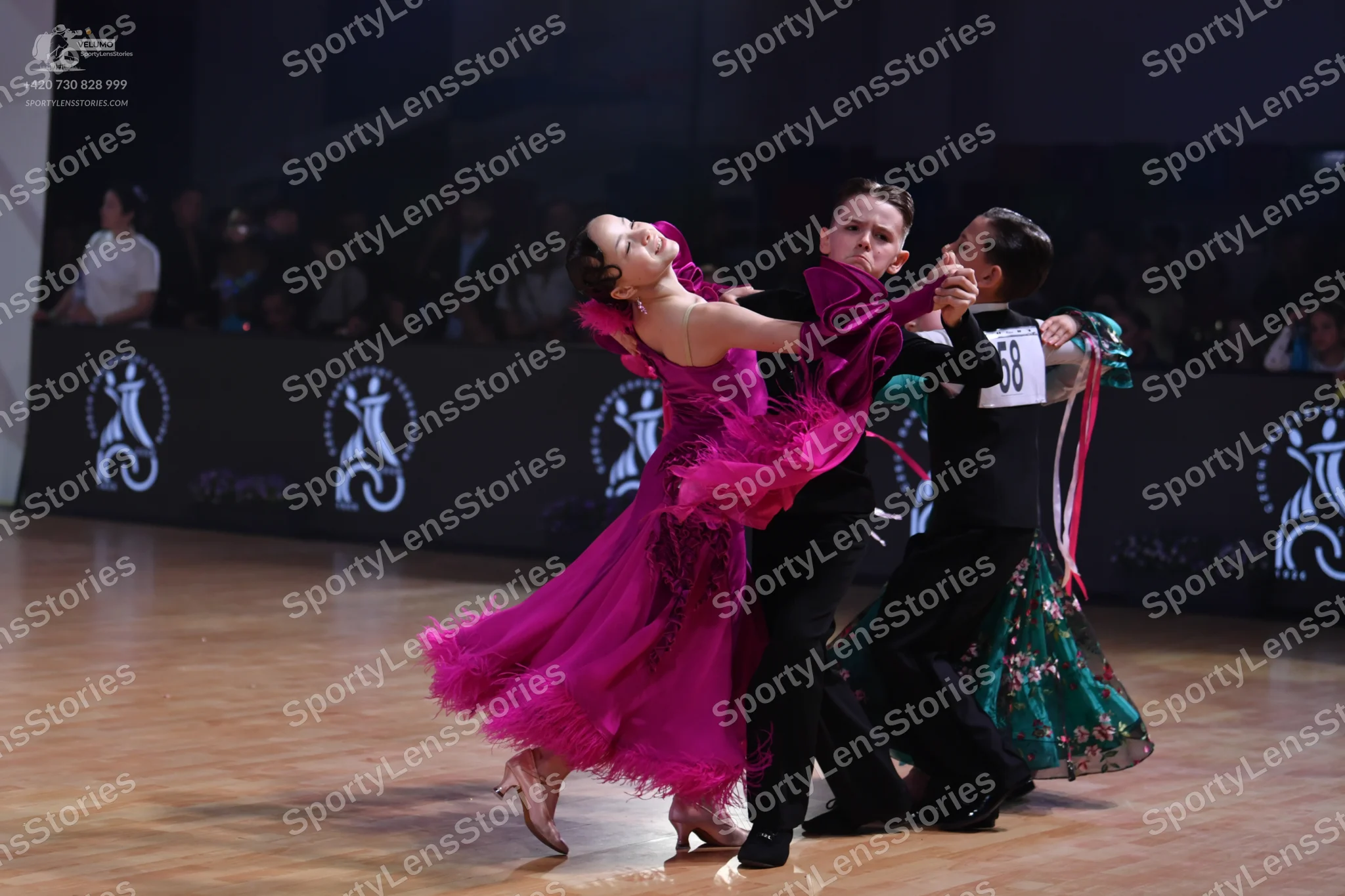 Dancesport competitor: Female dancer: magenta ballroom dress with multiple layers of fringe