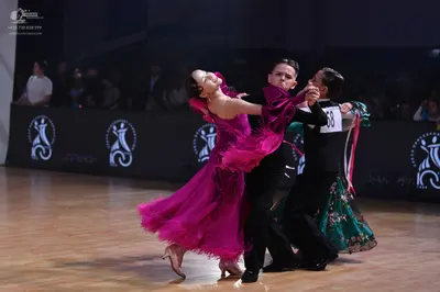 Dancesport competitor: Female dancer: magenta ballroom dress with multiple layers of fringe