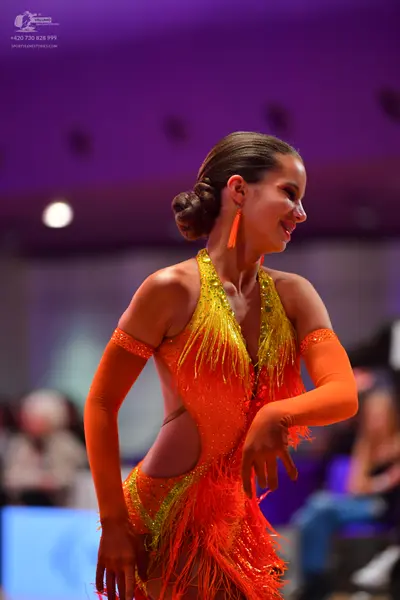 Dancesport competitor: Female dancer: yellow and orange latin dress with sequins and fringe, with match