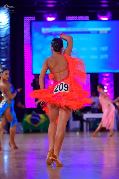 Dancesport competitor #209: Female dancer in center: orange/red Latin dress with long fringe