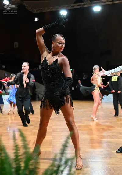 Dancesport competitor #74: Female dancer in foreground: black sequin Latin dress with fringe, long black gl