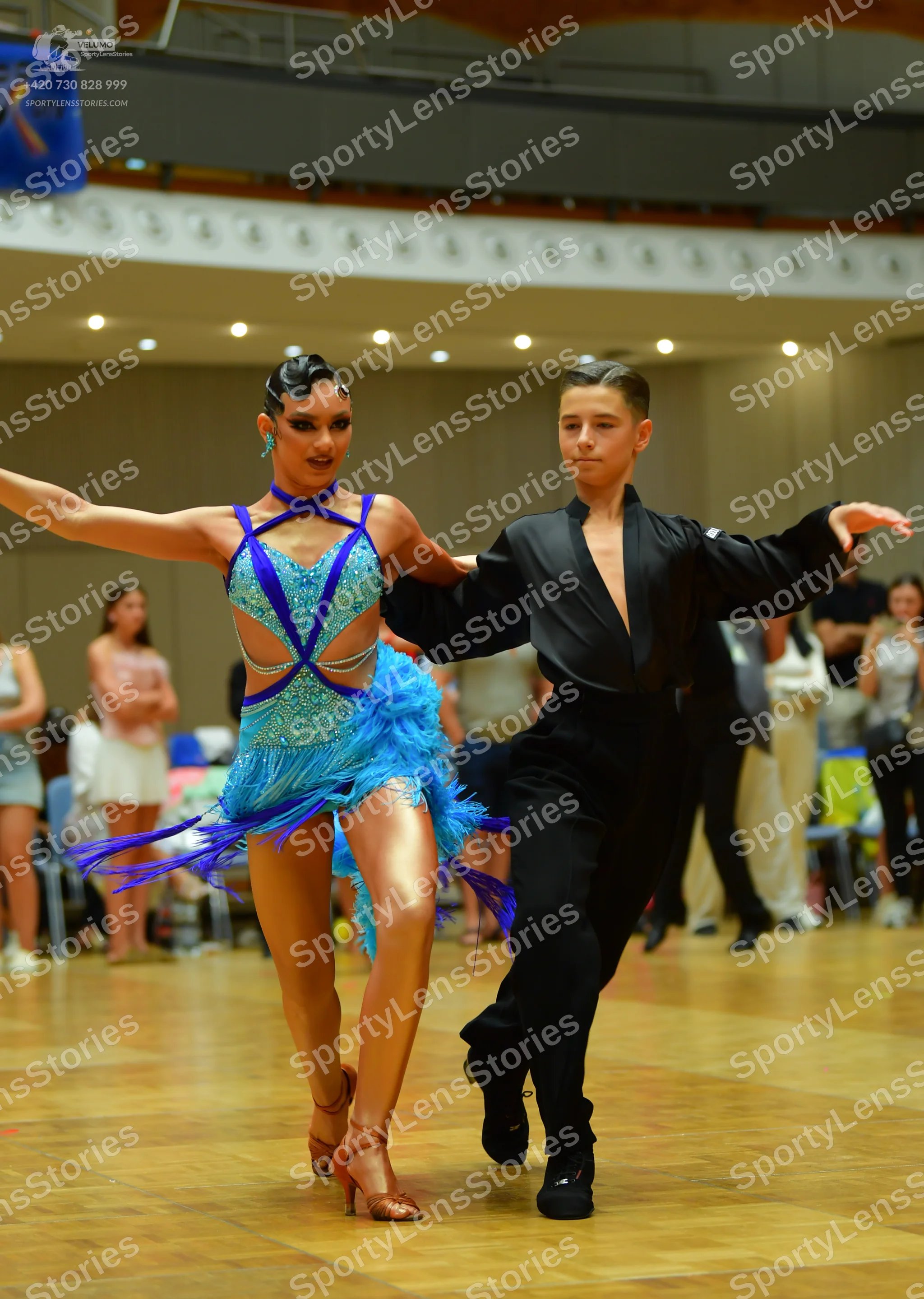 Dancesport competitor: Female dancer: bright blue Latin dance dress with a cutout top and long blue fri