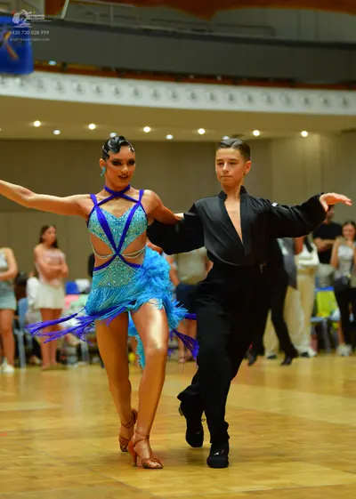 Dancesport competitor: Female dancer: bright blue Latin dance dress with a cutout top and long blue fri