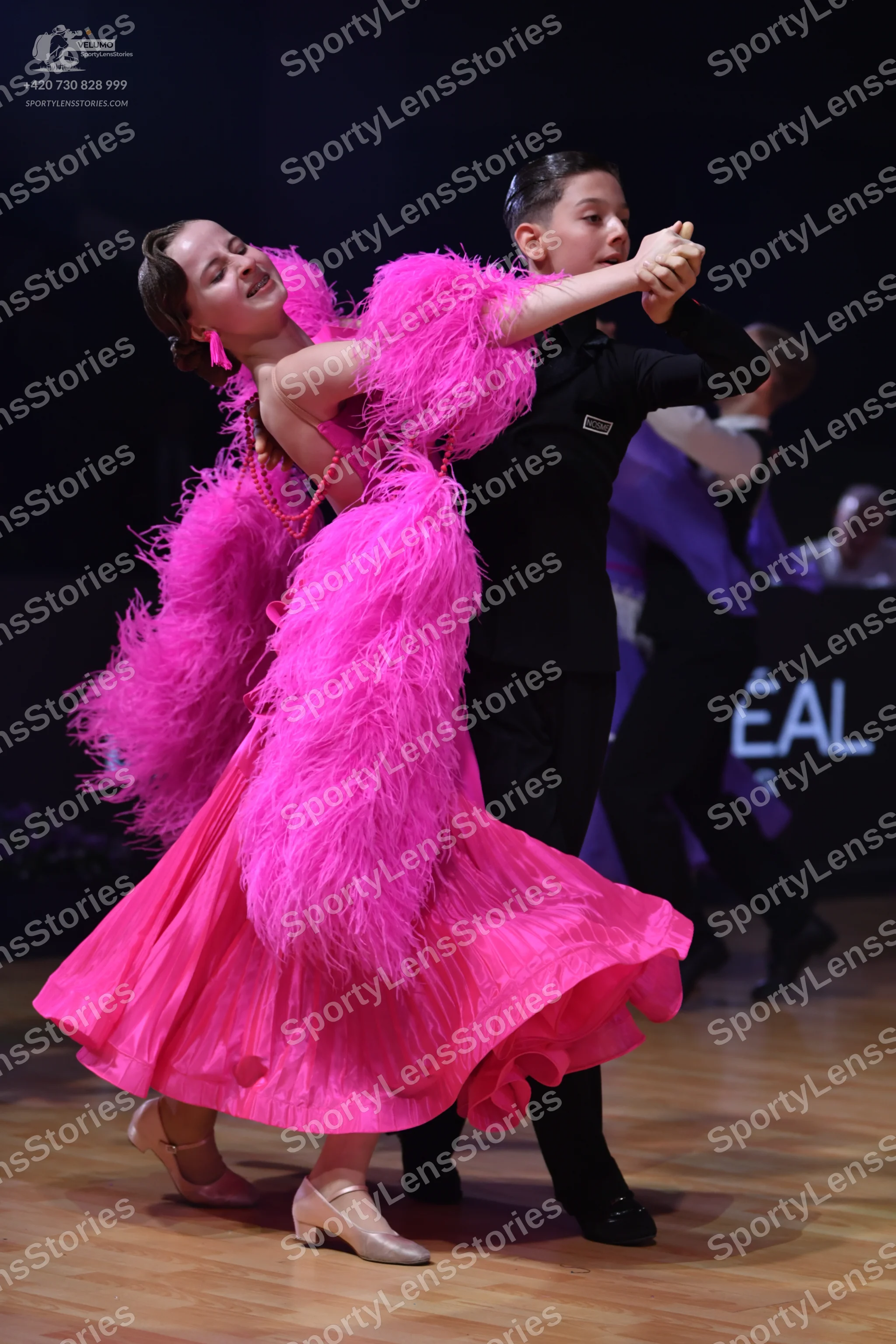 Dancesport competitor: Female dancer: bright pink Latin dance dress with large, voluminous pink feather