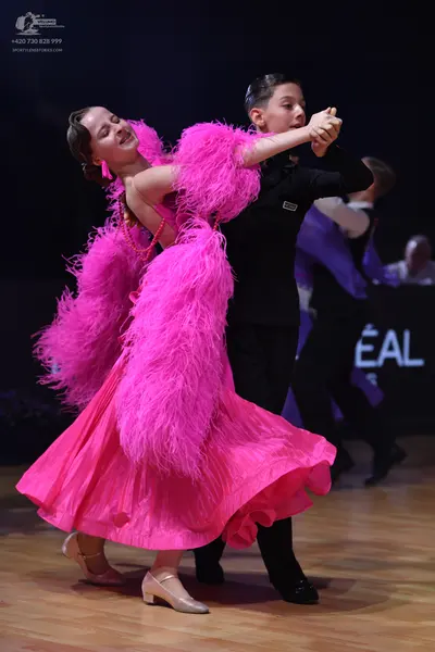 Dancesport competitor: Female dancer: bright pink Latin dance dress with large, voluminous pink feather