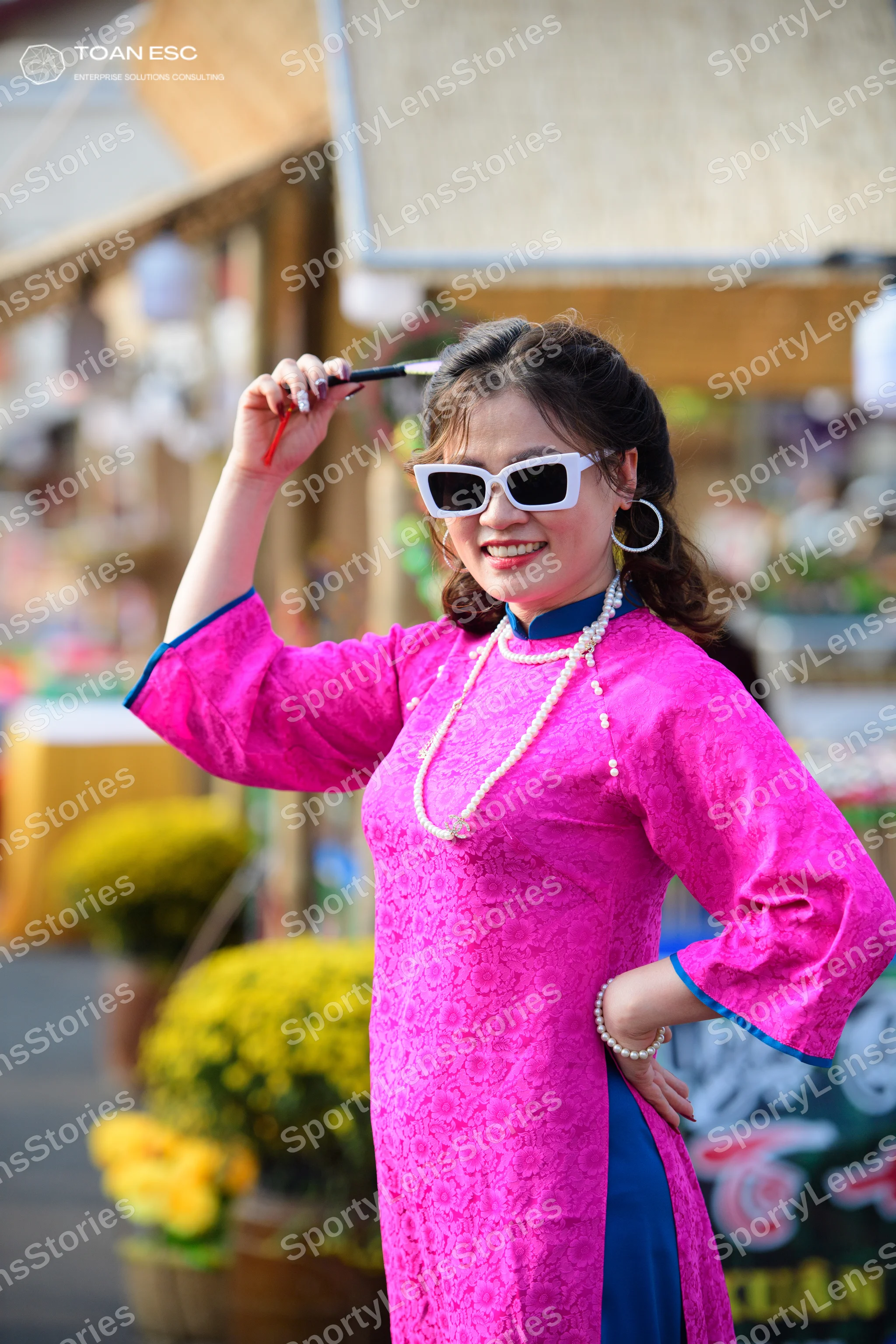 Dancesport competitor: Female dancer: bright pink long-sleeved tunic with dark blue trim on the sleeves