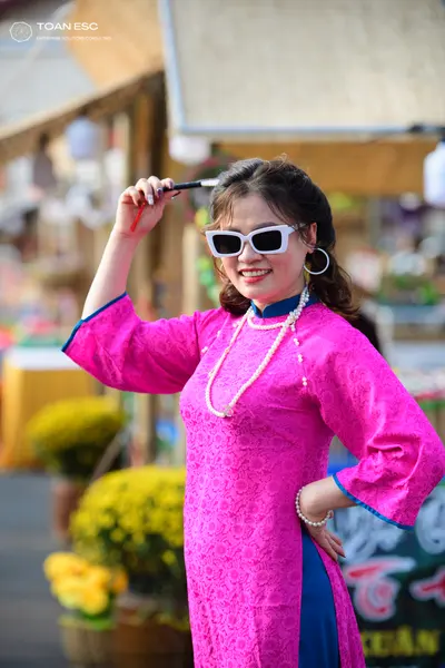 Dancesport competitor: Female dancer: bright pink long-sleeved tunic with dark blue trim on the sleeves