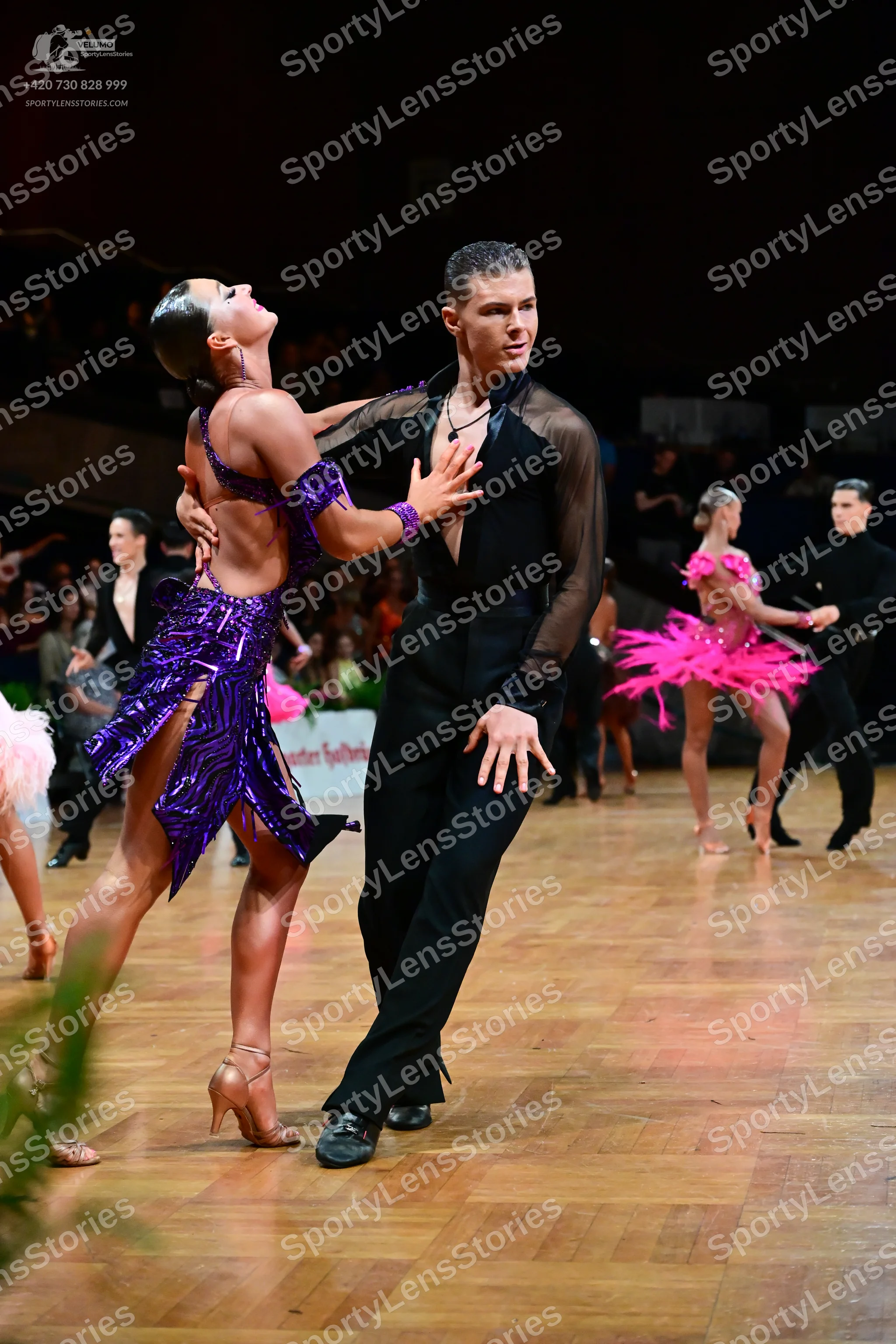 Dancesport competitor: Main female dancer: purple Latin dance dress with sequins and cutouts