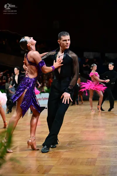Dancesport competitor: Main female dancer: purple Latin dance dress with sequins and cutouts
