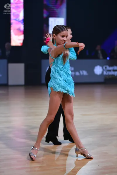 Dancesport competitor: Female dancer: light blue Latin dress with fringe and straps, silver metallic da