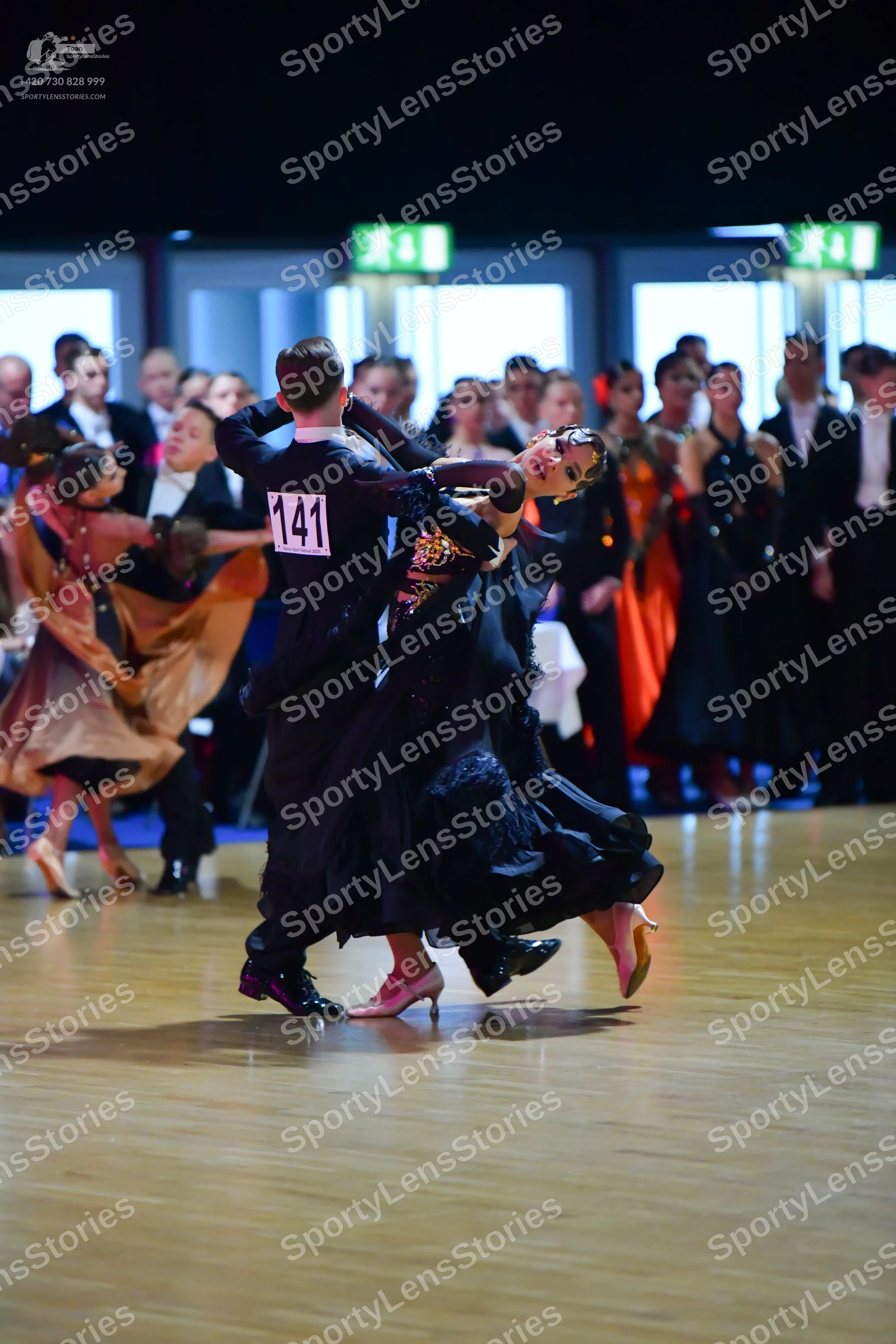 Dancesport competitor #141: Male dancer (center): black suit, white shirt, and black bow tie