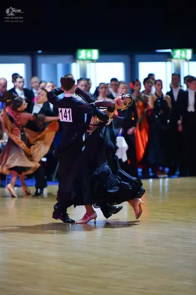 Dancesport competitor #141: Male dancer (center): black suit, white shirt, and black bow tie