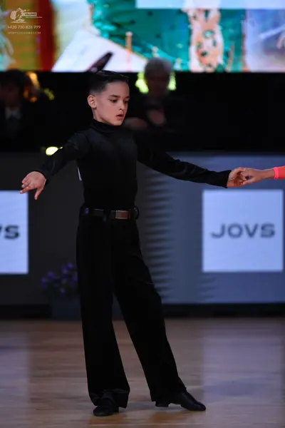 Dancesport competitor: Male dancer: black long-sleeved top and black wide-leg trousers with a black bel