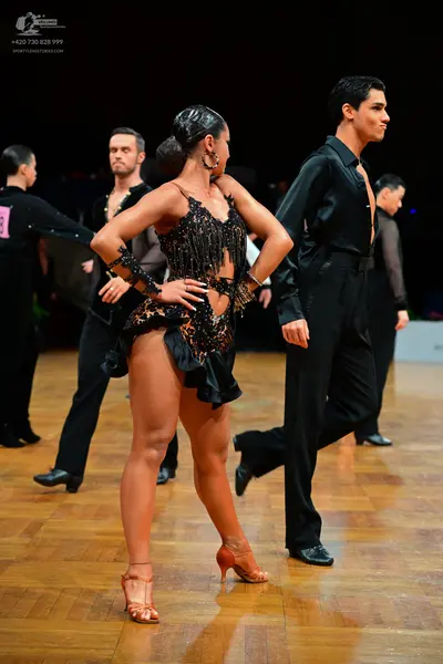 Dancesport competitor: Female dancer: black Latin dance dress with sequins, beads, and fringe