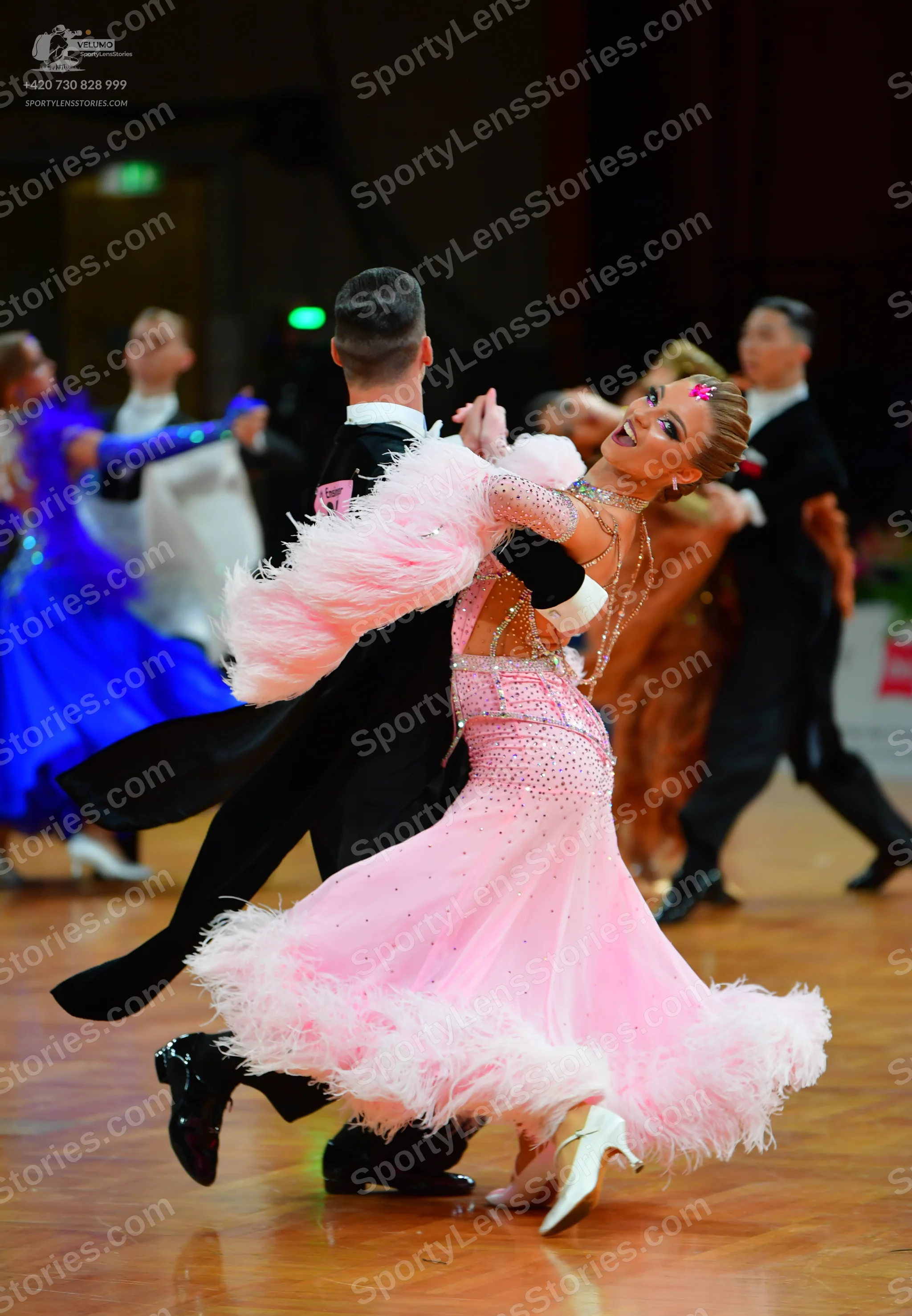 Dancesport competitor: Female dancer in foreground: pink ballroom dress embellished with sequins and rh