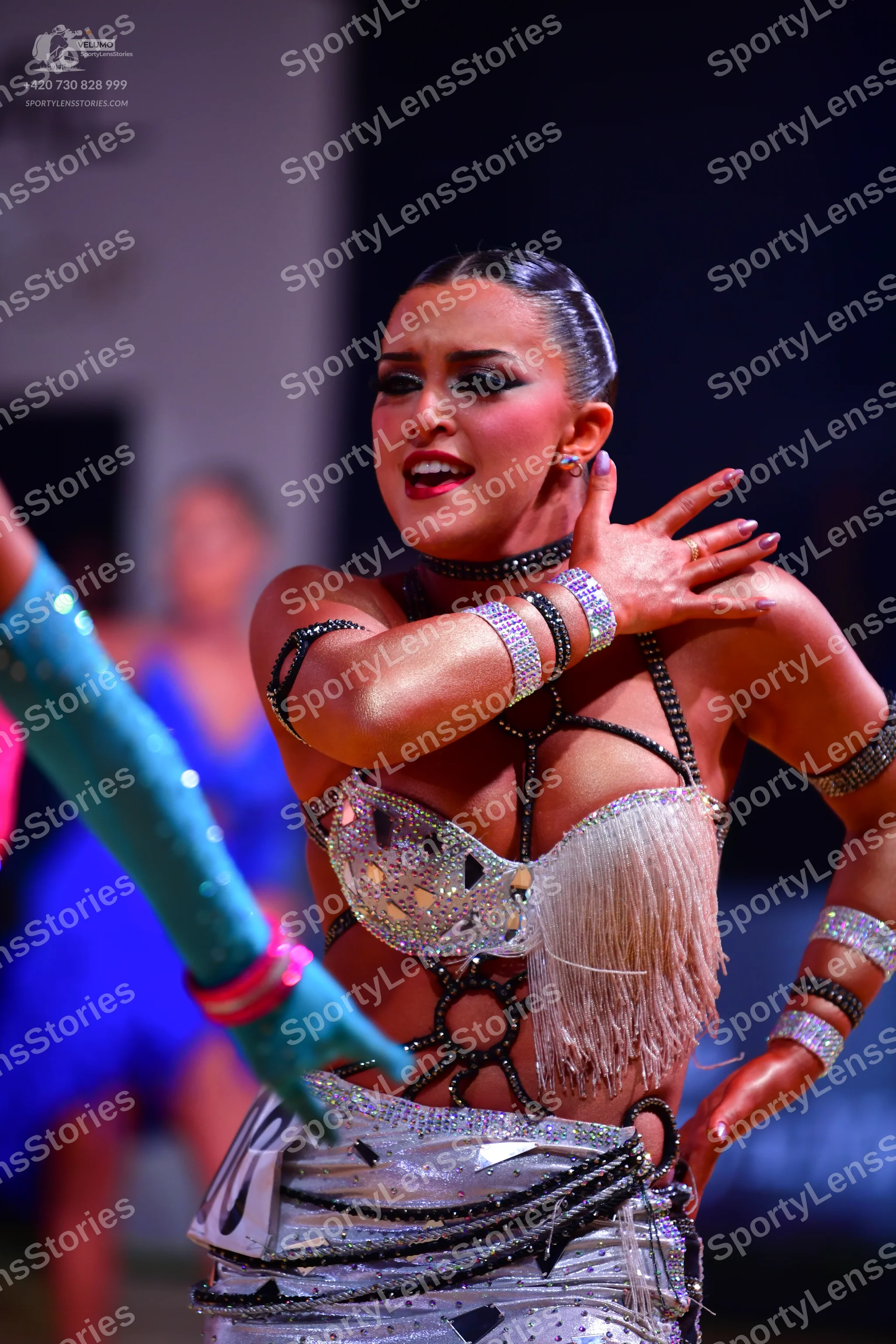 Dancesport competitor: Female dancer: silver and black latin dress decorated with crystals, sequins, an