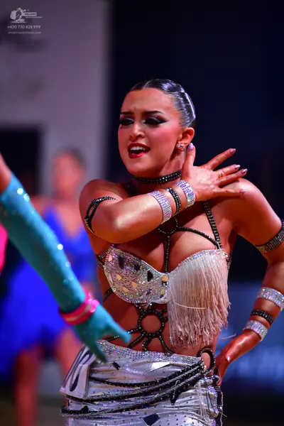 Dancesport competitor: Female dancer: silver and black latin dress decorated with crystals, sequins, an
