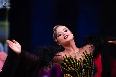 Dancesport competitor: Female dancer: black Latin dance dress with gold/yellow sequin and crystal embel