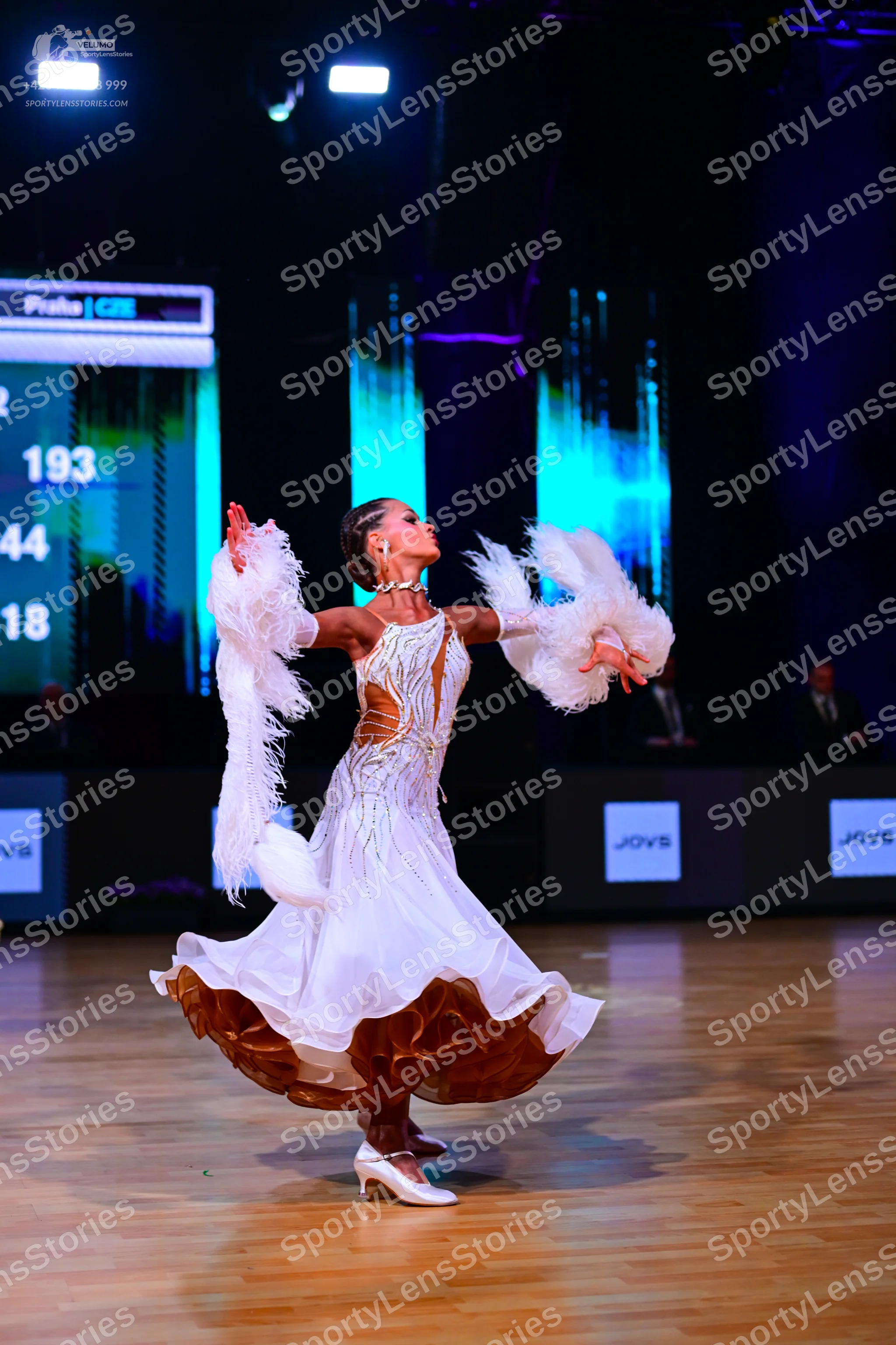 Dancesport competitor: Female dancer: white ballgown with gold sequin patterns on the bodice and a mult