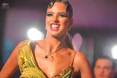 Dancesport competitor: Female dancer: gold/yellow latin dress with multi-colored sequins and thin strap