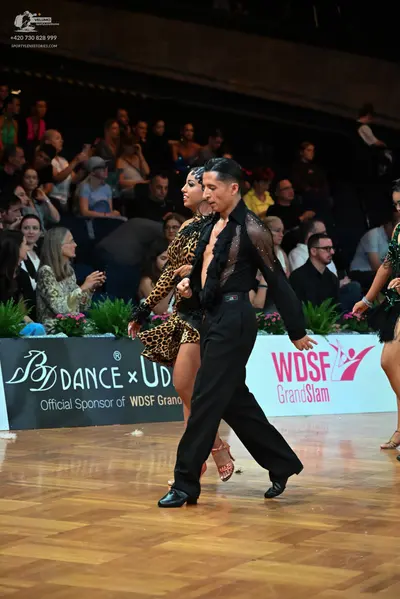 Dancesport competitor: Male dancer: black long-sleeved shirt with sheer mesh panels and black trousers