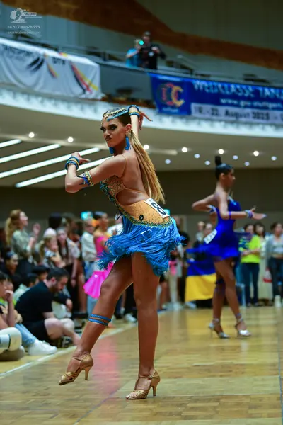 Dancesport competitor #11: Female dancer 1: gold/beige sequined Latin dance dress with blue fringe, blue he