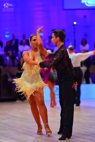 Dancesport competitor: Female dancer: pale yellow latin dress with sequins and long fringe