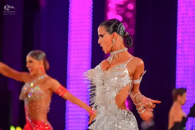 Dancesport competitor: Female dancer in foreground: silver latin dress with sequins, rhinestones, side 