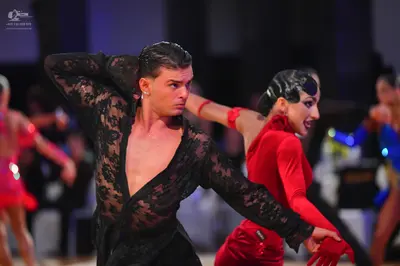 Dancesport competitor: Male dancer: black lace long-sleeved shirt, open at the chest, and black trouser