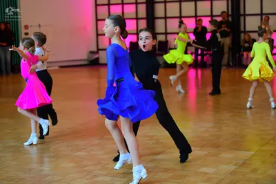 Dancesport competitor: Female dancers: pink, blue, and yellow latin dresses with short, flared skirts