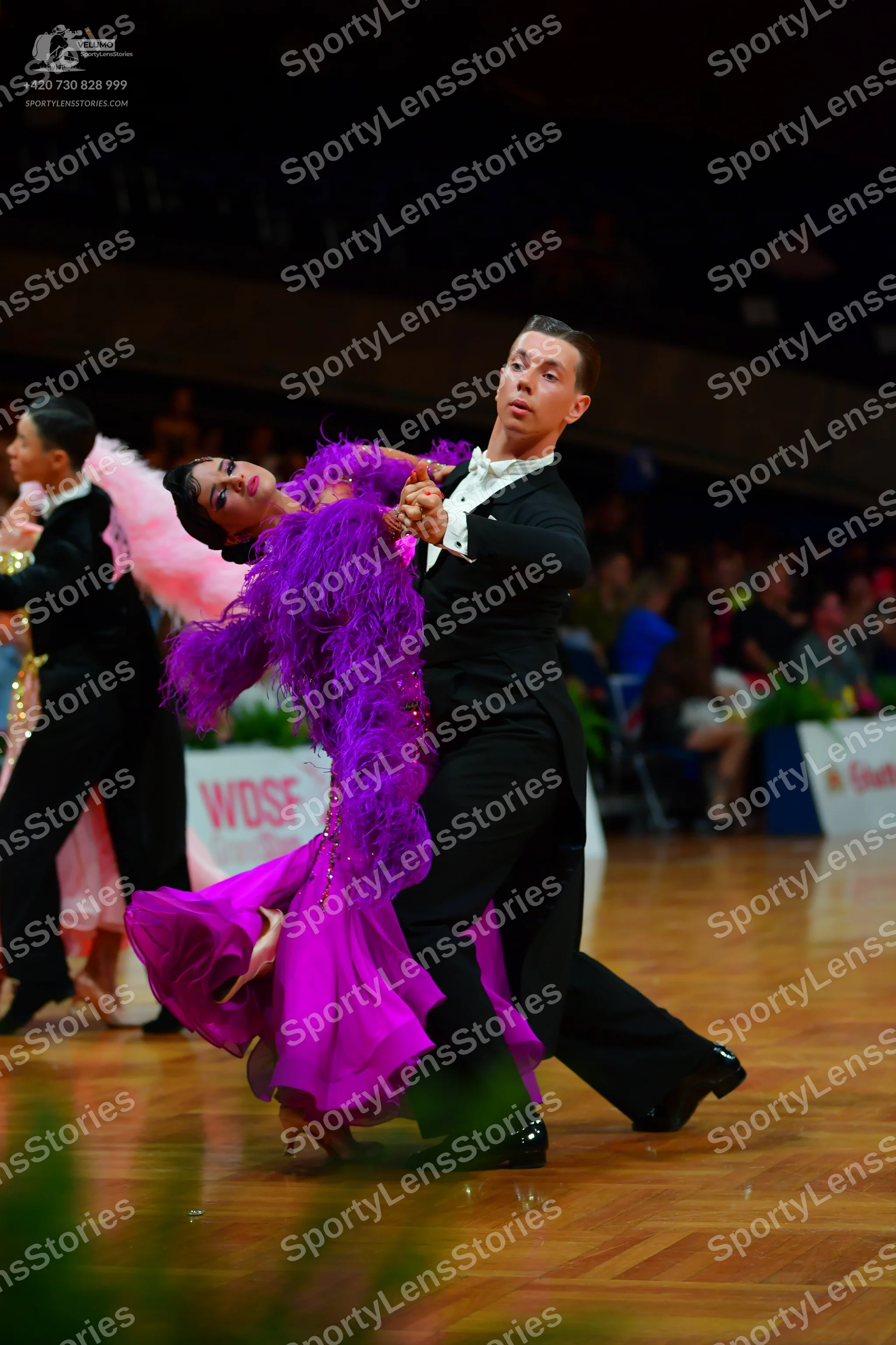 Dancesport competitor: Female dancer: purple latin dress with large feather trim