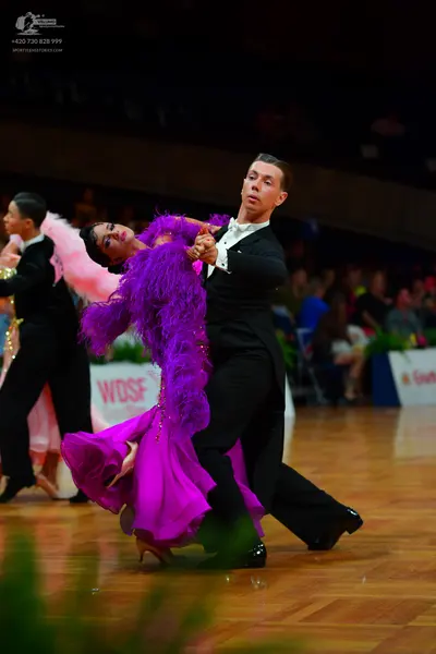 Dancesport competitor: Female dancer: purple latin dress with large feather trim