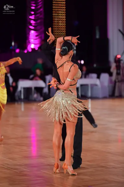 Dancesport competitor: Female dancer: gold/champagne sequined Latin dress with a bra-style top and a me