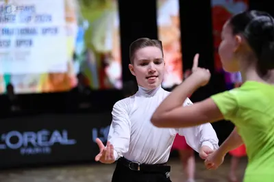 Dancesport competitor: Male dancer: white long-sleeved shirt and black trousers with a black belt