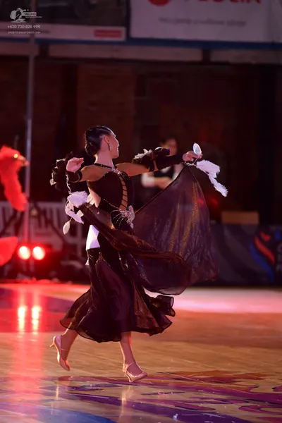 Dancesport competitor: Female dancer: black ballroom dress with a flowing skirt, lace or sequin detaili