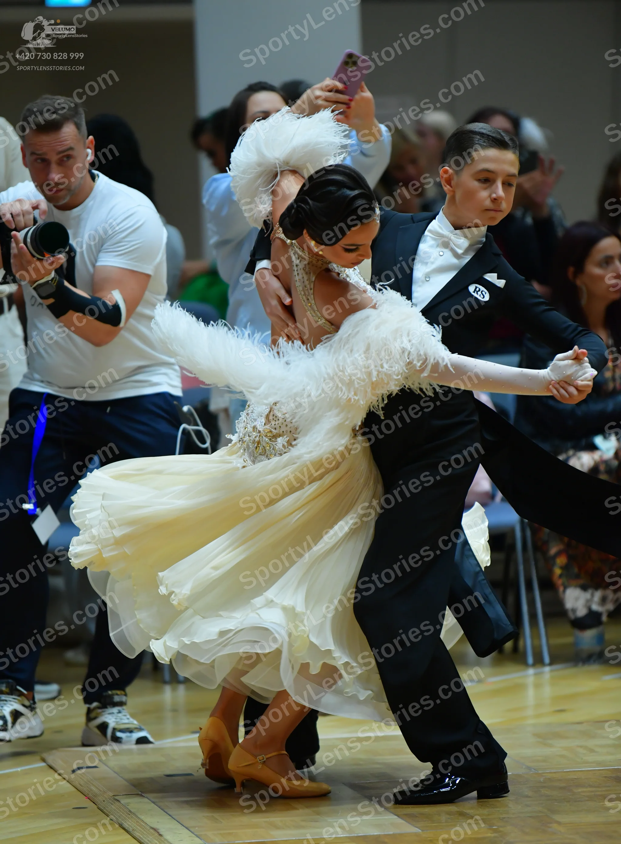 Dancesport competitor: Male dancer: black suit with a white shirt, white bow tie, and a small white pat