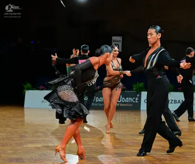 Dancesport competitor: Male dancer: black long-sleeve shirt with silver sequin patterns on the chest an