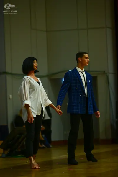 Dancesport competitor: Female dancer: white long-sleeved button-down shirt and black leggings