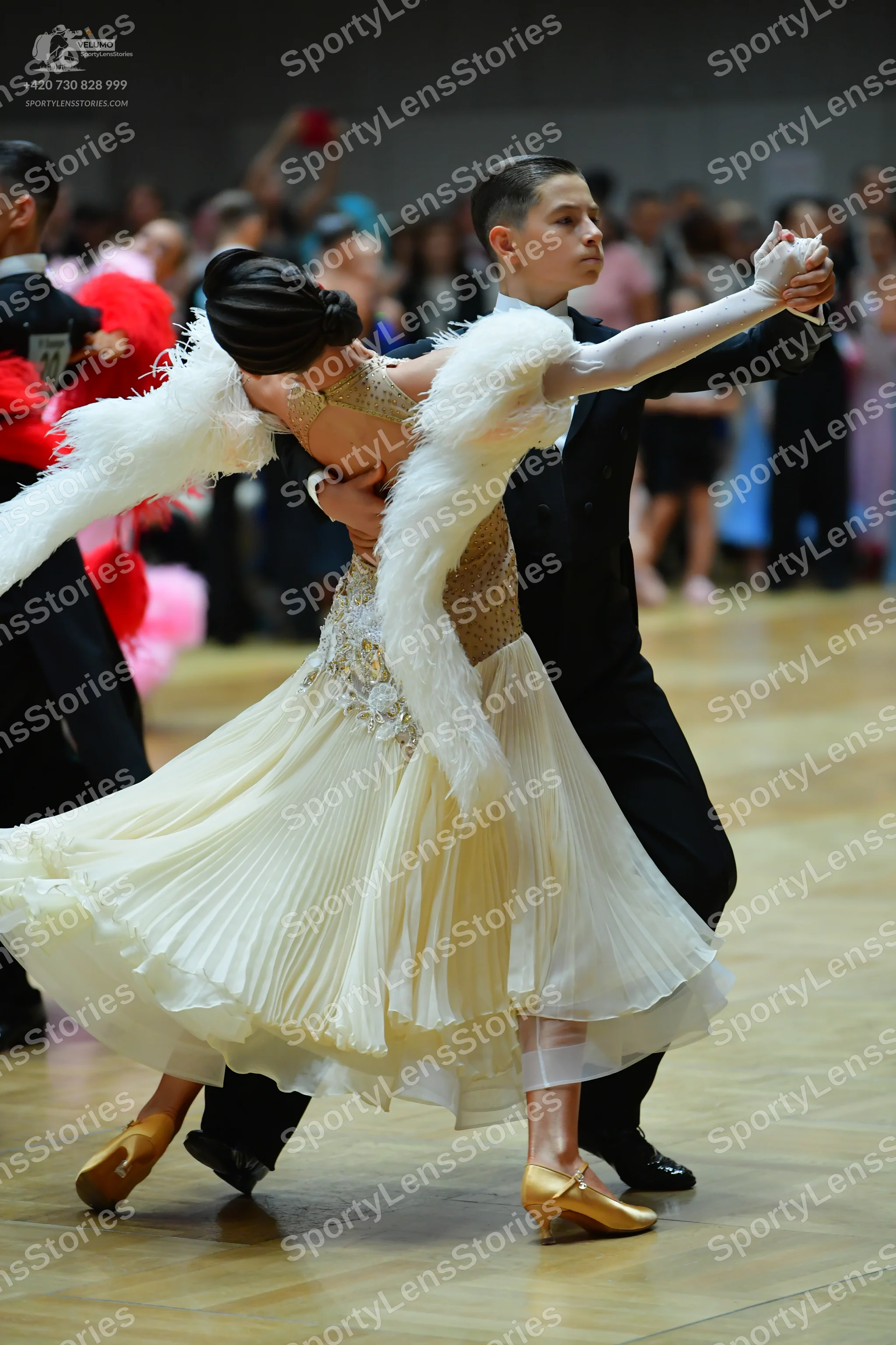 Dancesport competitor: Female dancer: cream-colored ballroom dress with a sequined bodice, a voluminous